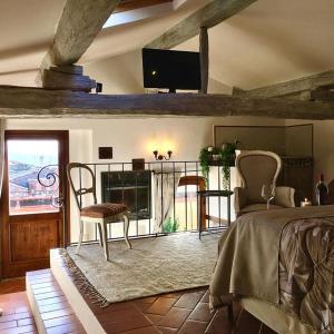 a bedroom with a bed and a table and a television at Il Giglio B&B in Pienza