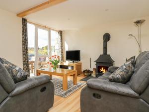 a living room with two couches and a fireplace at Mynheer Farm Barn in Redruth
