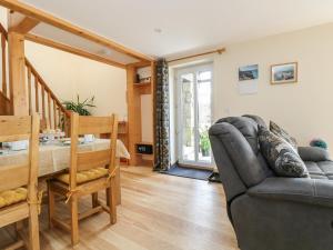 a living room with a couch and a chair at Mynheer Farm Barn in Redruth