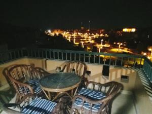 a table and chairs on a balcony at night at Marina Wadi Degla villa duplex 4 Rooms Ain Sokhna in Ain Sokhna