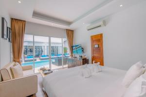 a bedroom with two beds and a view of a pool at The Privilege Hotel Ezra Beach Club in Bangrak Beach