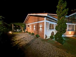 ein Haus in der Nacht mit einem Weg dorthin in der Unterkunft Toca - Bairro Serrano in São Bento do Sapucaí