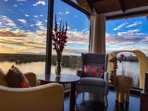 Habitación con sillas, mesa y ventana grande. en Amalia Titicaca Lodge, en Puno