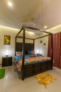 ein Schlafzimmer mit einem Himmelbett und einem Spiegel in der Unterkunft Serenity Corner in Islamabad