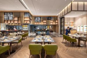 Una representación de un restaurante con mesas y sillas. en Holiday Inn Zhengzhou High-Tech Zone by IHG, en Zhengzhou