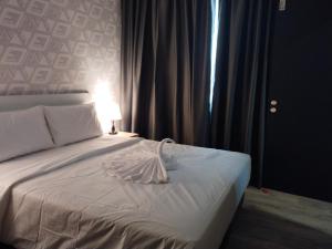 a bedroom with a white bed with a lamp on it at SRITEL BOUTIQUE HOTEL in Shah Alam