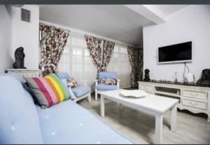 a living room with a couch and a tv at The White Hotel Alaçatı in Alaçatı