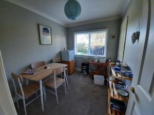 a dining room with a table and chairs and a window at Tui Glade Bed and Breakfast in Cambridge