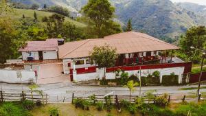 Eco Lodge La Juanita في مانيزاليس: منزل بسقف احمر على جبل