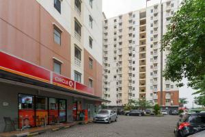 a car parked in a parking lot in front of a building at Apartemen Cibubur Village by Raja Sulaiman Property in Cibubur