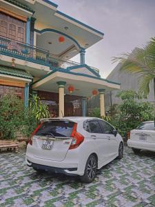 a white car parked in front of a house at Noel Homestay in Hiếu Xương