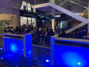 a group of people sitting at tables in a mall at Olympic Residence Deluxe Apartments in Limassol