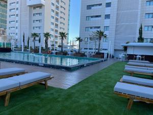 a large swimming pool in a building with benches at Olympic Residence Deluxe Apartments in Limassol