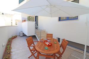 een tafel en stoelen met een parasol op een terras bij Delightful Caterinas house in Otranto in Otranto