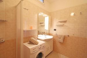 een badkamer met een wasmachine en een wastafel bij Delightful Caterinas house in Otranto in Otranto +32 foto's