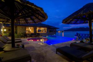 un resort con piscina di notte di Colibri Hotel a Baie Sainte Anne