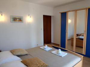 a bedroom with two beds and a large mirror at Apartman Vrsi in Vrsi