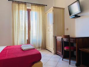 利帕里的住宿－Mamamia Lipari，一间卧室配有一张床、一张书桌和一台电视