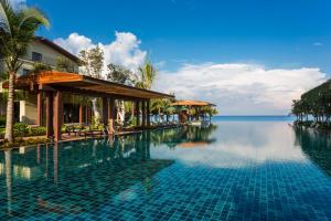ein Pool in einem Resort mit dem Meer im Hintergrund in der Unterkunft Dusit Princess Moonrise Beach Resort in Phu Quoc