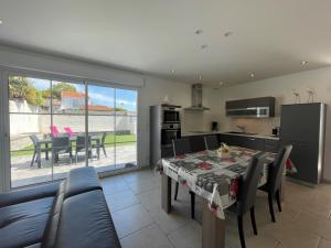 a kitchen and a dining room with a table and chairs at La petite rétaise in La Flotte