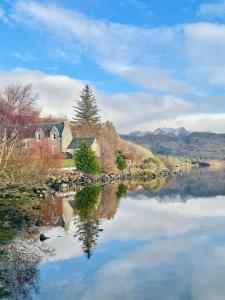 a house on the shore of a lake at Loch Morar Private Suite in Mallaig