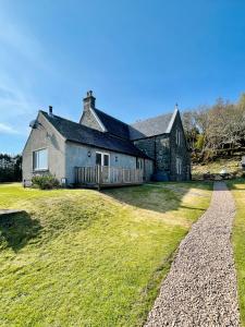 une maison sur une colline herbeuse avec un chemin dans l'établissement Loch Morar Private Suite, à Mallaig