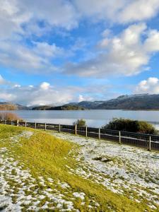 a fence next to a body of water at Loch Morar Private Suite in Mallaig