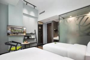 1 dormitorio con cama blanca y espejo en Spring Time Hotel, en Guangzhou