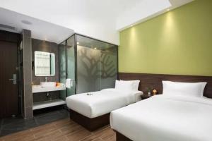 Habitación de hotel con 2 camas y baño en Spring Time Hotel, en Guangzhou