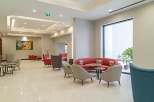 a waiting room with a red couch and chairs at Sundia Exclusive By Liberty Fethiye Adults Only in Fethiye