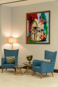 a living room with two chairs and a painting on the wall at Sundia Exclusive By Liberty Fethiye Adults Only in Fethiye