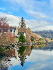 a house on the shore of a river at Loch Morar Private Suite in Mallaig