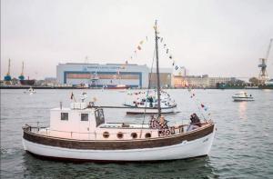 a boat in a body of water with other boats at Historical boat Tu vėjo paklausk in Klaipėda