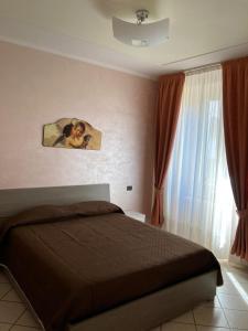 1 dormitorio con 1 cama y una ventana con cortinas en Pasubio House casa vacanze, en Campobasso