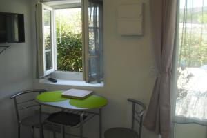 a small table with a book on it next to a window at Jasmin in Gordes