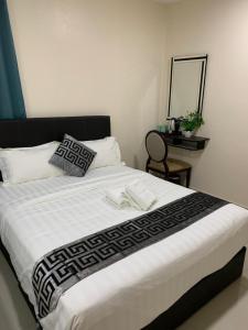 a bedroom with a large bed with a mirror and a table at Hotel VGO in Kuala Lumpur