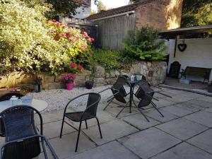 a patio with three chairs and a table in a yard at Jolly Sailor in Cawood