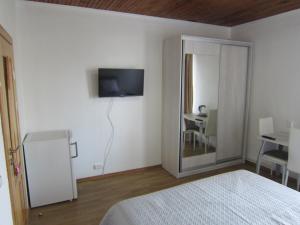 a bedroom with a bed and a television on the wall at Kambarių nuoma Palangoje in Palanga