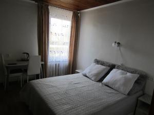 a bedroom with a bed with two pillows and a window at Kambarių nuoma Palangoje in Palanga