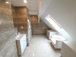 een badkamer met een wastafel, een toilet en een trap bij Apartmány v centru - Lázně Kynžvart in Lázně Kynžvart