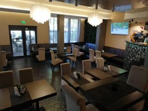 une salle à manger avec des tables, des chaises et des lustres dans l'établissement Hotel Ponti, à Vidin