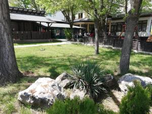 a garden with rocks and trees and a building at Hotel Ponti in Vidin