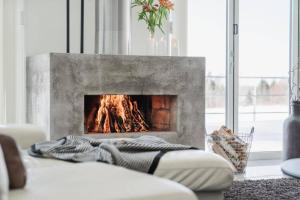 einen Kamin im Wohnzimmer mit einer Decke auf dem Sofa in der Unterkunft Modern & luxury 8p villa with 25 sqm SPA and stunning views and private surroundings in Hortlax