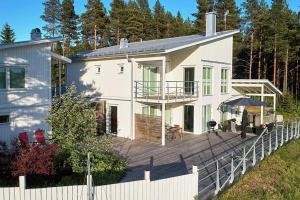 een groot wit huis met een houten terras bij Modern & luxury 8p villa with 25 sqm SPA and stunning views and private surroundings in Hortlax