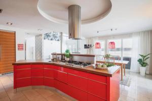 a kitchen with red cabinets and a red counter top at Modern & luxury 8p villa with 25 sqm SPA and stunning views and private surroundings in Hortlax