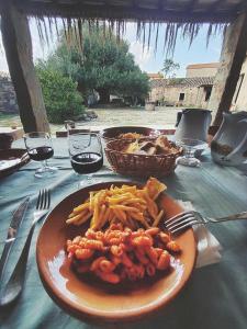 une assiette de pâtes et de frites sur une table dans l'établissement Omu Axiu, à Orroli