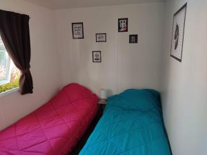 two beds sitting in a room with a window at Mobil-home climatisé à Valras Plage dans le camping 4 étoiles les Sables du midi à 800m de la plage in Sérignan