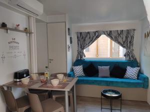 a living room with a blue couch and a table at Mobil-home climatisé à Valras Plage dans le camping 4 étoiles les Sables du midi à 800m de la plage in Sérignan