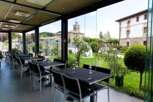 a restaurant with tables and chairs in front of a window at La Casa del Patrón in Murguía