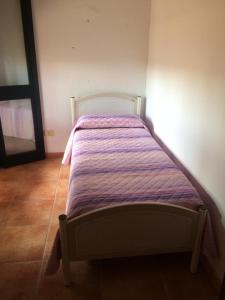 um quarto com uma cama com um edredão roxo em villa domenica em Torre Squillace